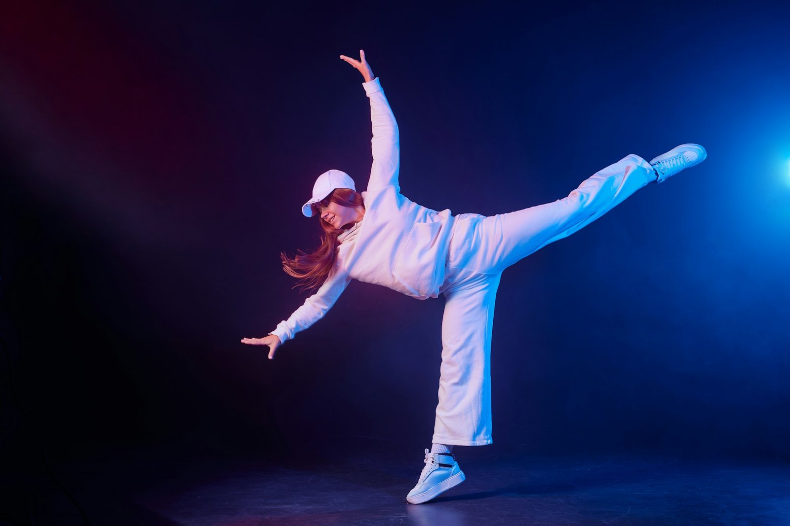 a girl in light clothes dances on a neon background in smoke, modern dance